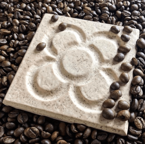 White speckled recycled coffee panot sitting in coffee beans