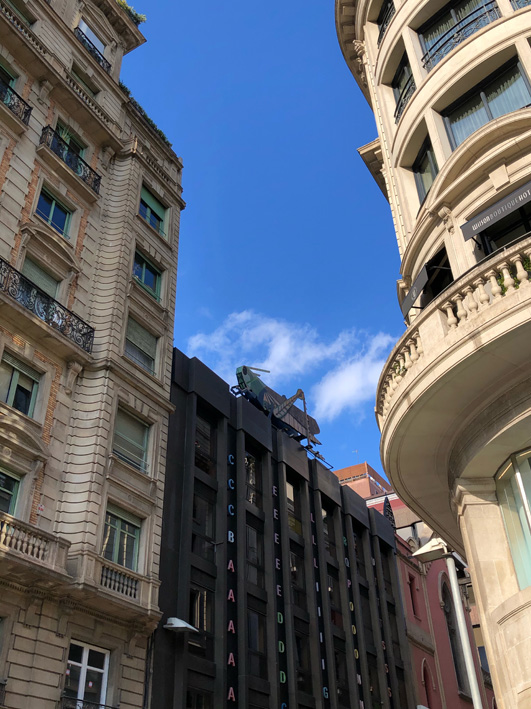 Street view of the giant grasshopper sculpture on top of the Barcelona Surveyors' Association building