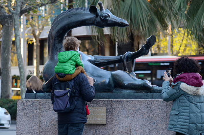 A family of three stop to take a photo of Coqueta, the flirtatious giraffe statue