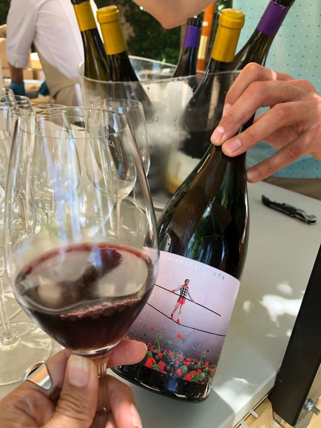 A glass of red wine alongside the bottle